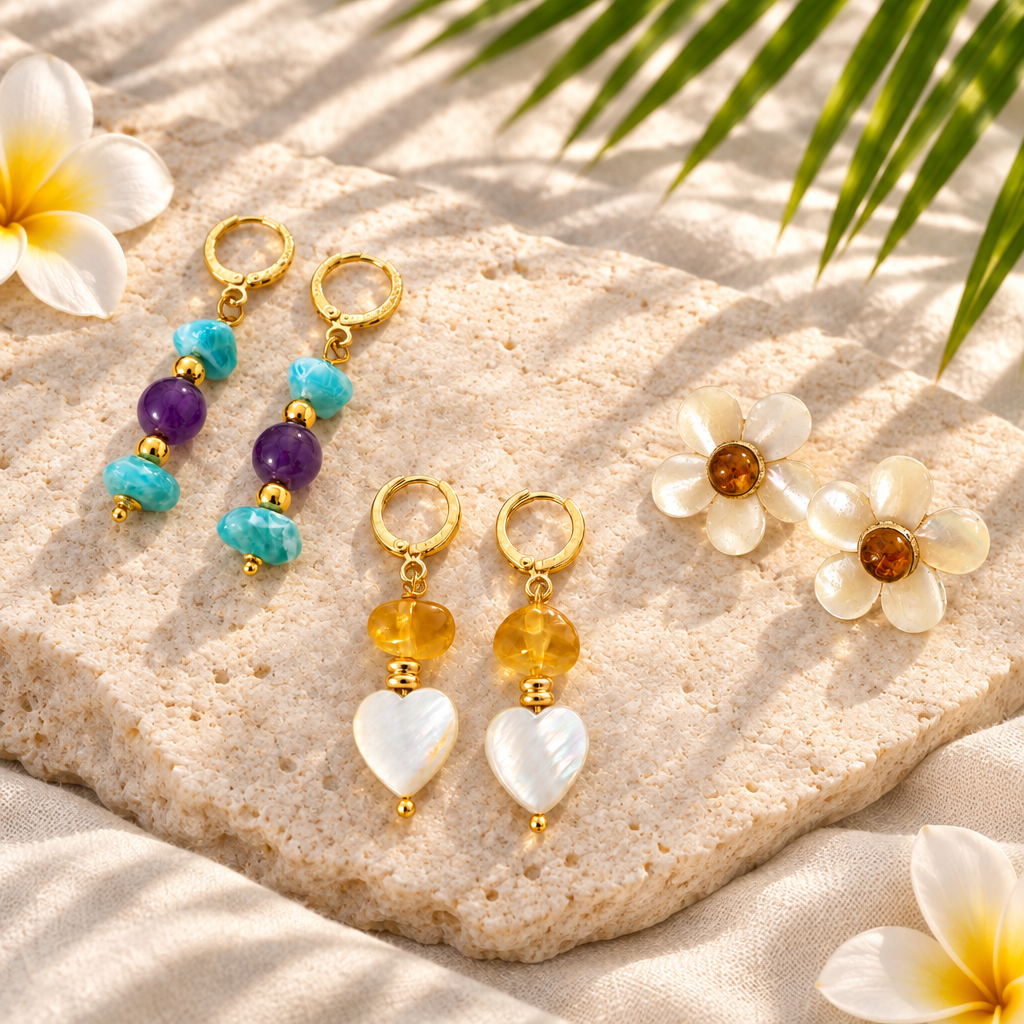 Aretes de ámbar con corazón de madreperla sobre piedra clara con flor de frangipani, hoja de palma y pétalos