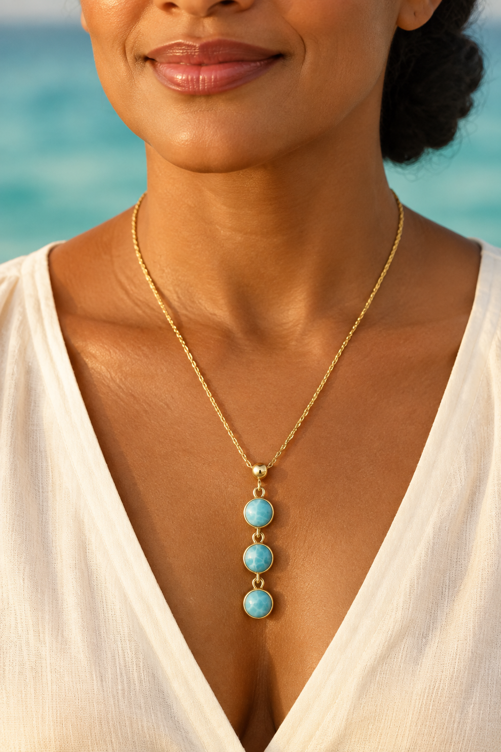 Collar de Larimar con tres piedras lucido por Maria, modelo caribeña madura con blusa marfil