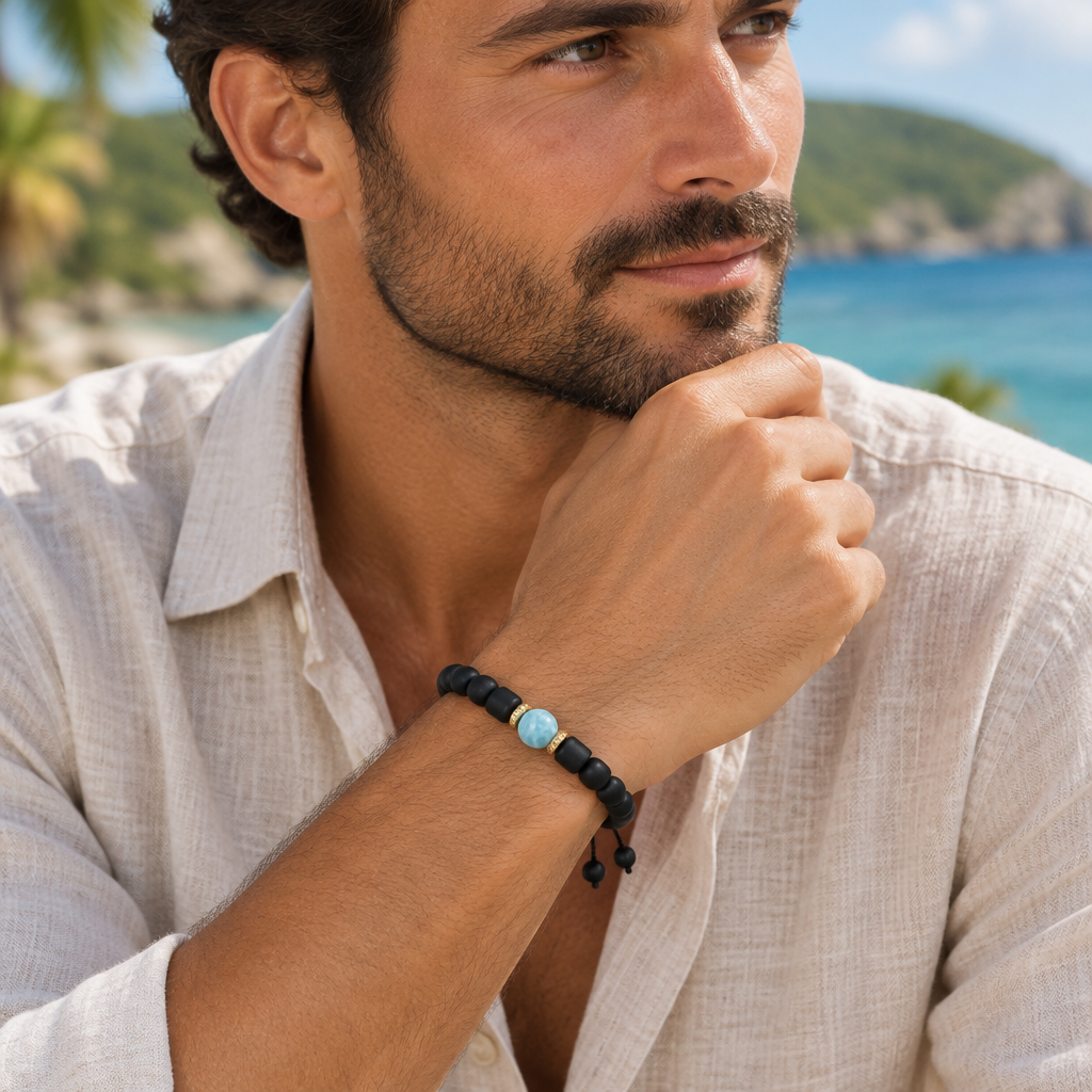 Hombre con pulsera de caucho negro, Larimar central y detalles en baño de oro en la muñeca