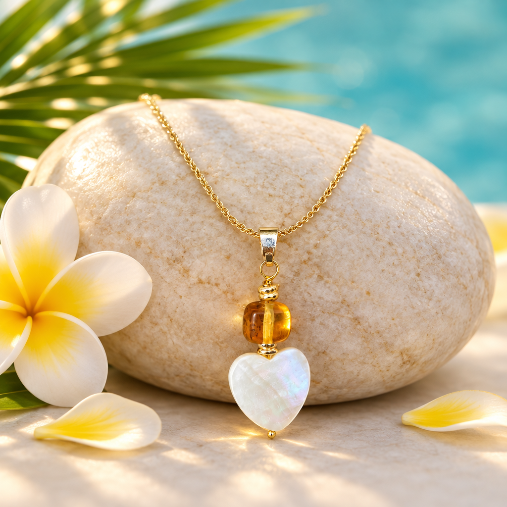 Collar de ámbar con corazón de madreperla sobre piedra clara con flor de frangipani, hoja de palma y pétalos