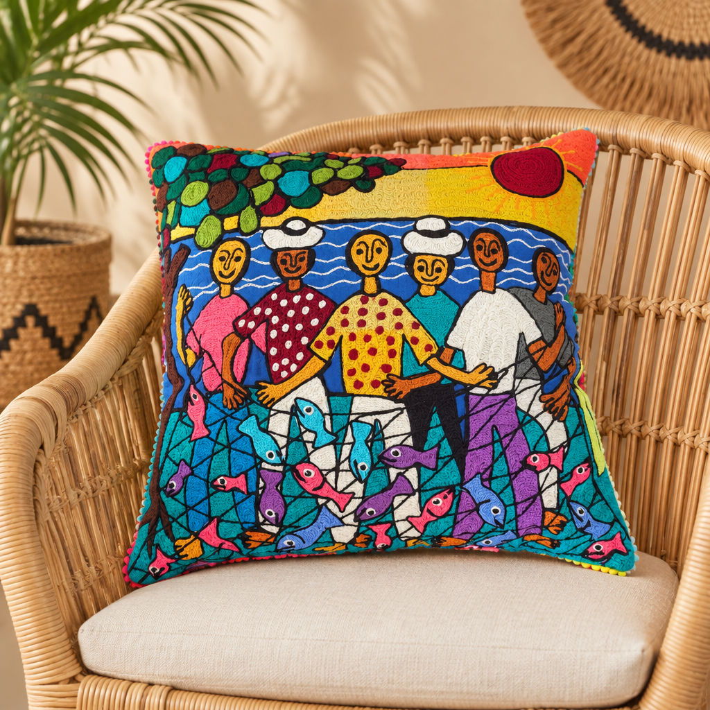 Cojín decorativo bordado con diseño original de José Morillo, motivo pescadores, sobre una silla de mimbre