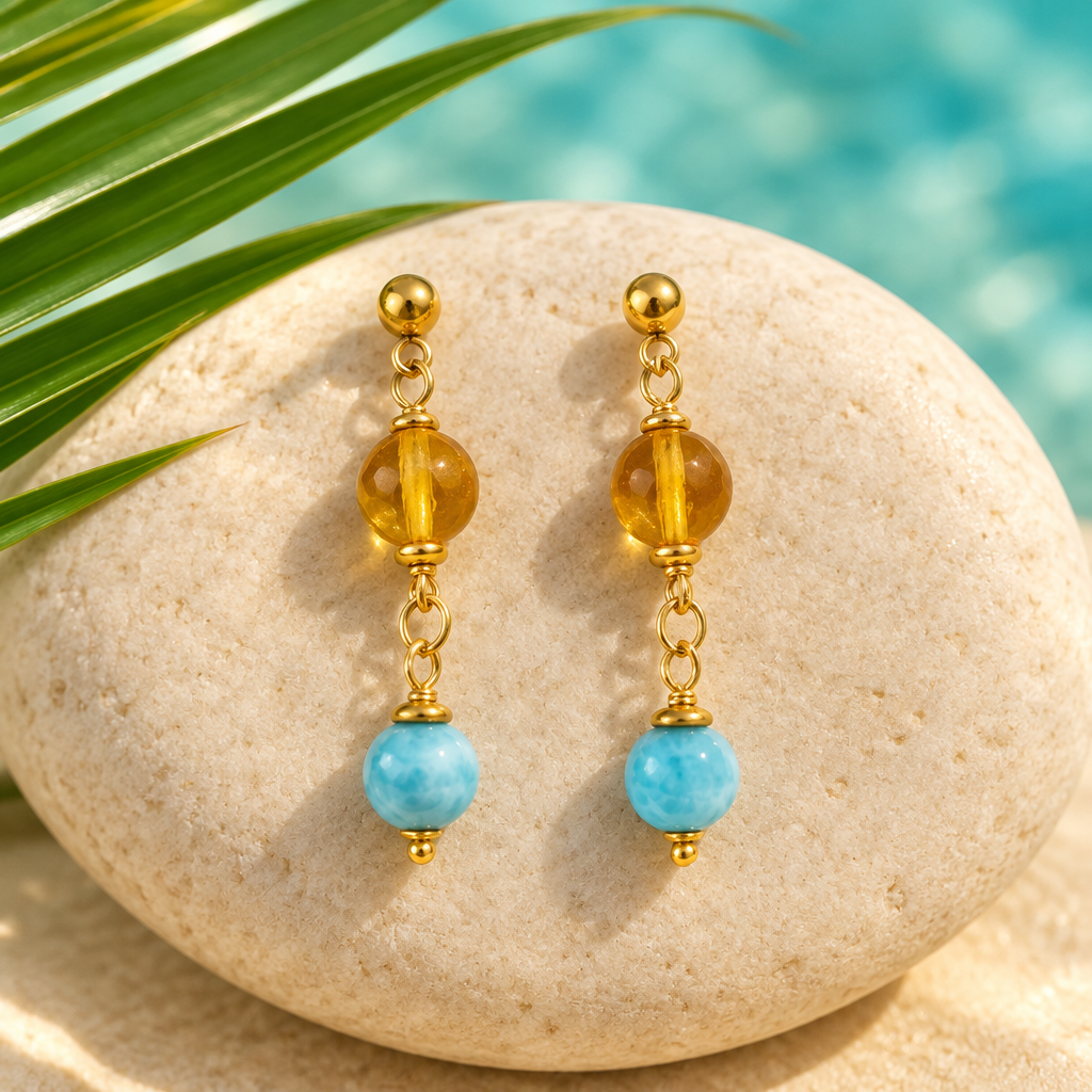 Par de aretes colgantes con ámbar y larimar sobre piedra crema con hoja de palma