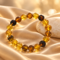 Pulsera de bolas de ámbar sobre seda color champán con piedra clara