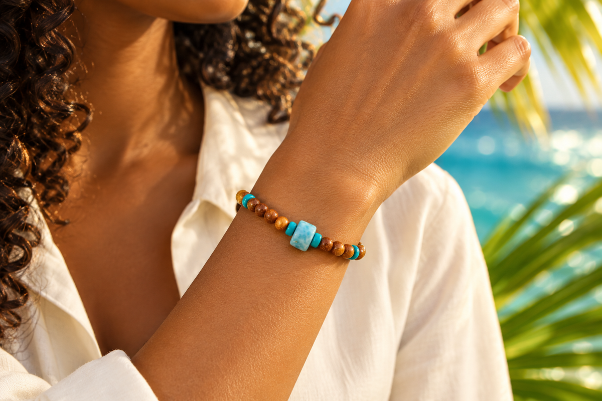 Pulsera de Arena Dorada, Larimar y Turquesa puesta en la muñeca de una mujer caribeña