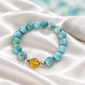 Pulsera de bolas de larimar, ámbar y plata sobre seda blanco perla con piedra clara