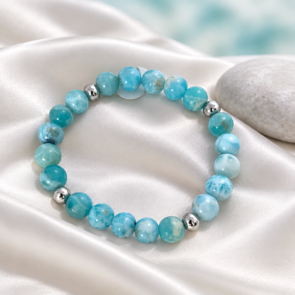Pulsera de bolas de larimar y plata sobre seda blanco perla con piedra clara