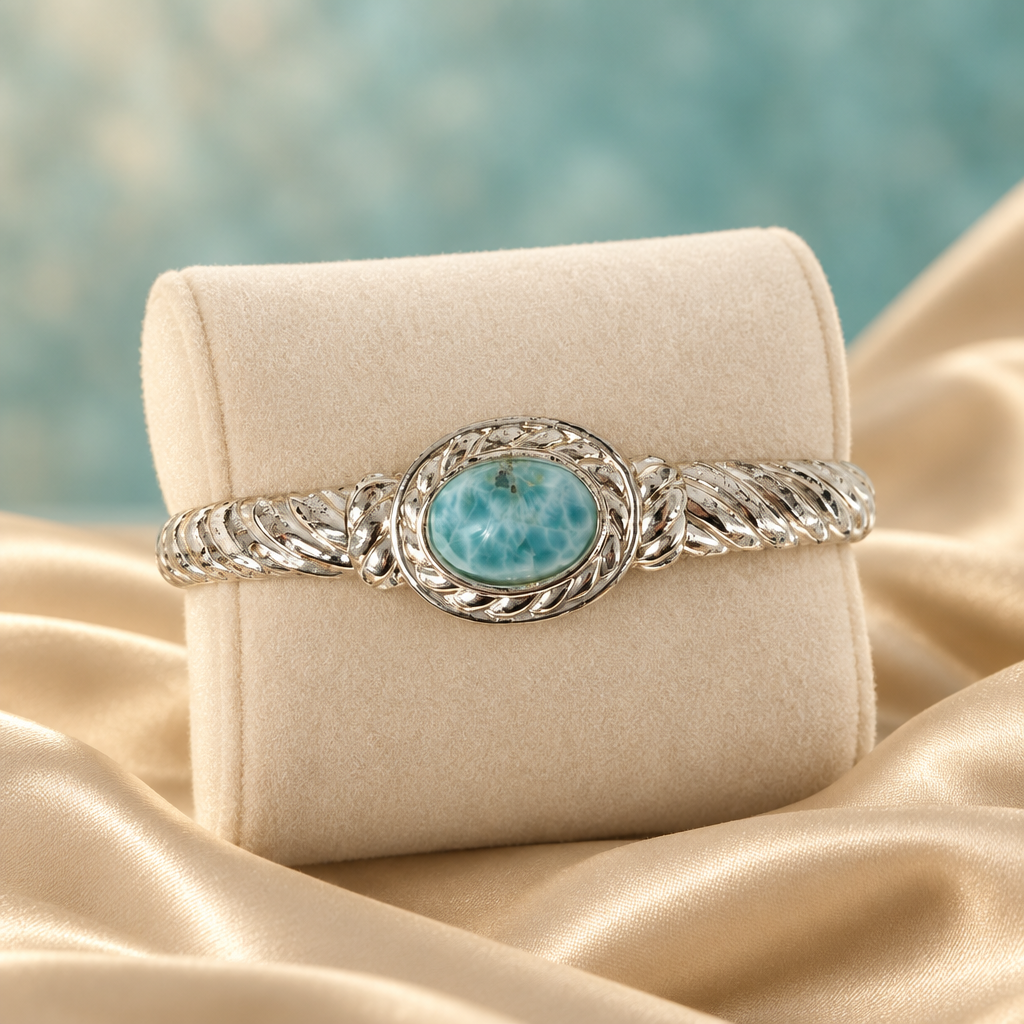 Pulsera de Larimar con acabado plateado sobre terciopelo marfil y seda champagne