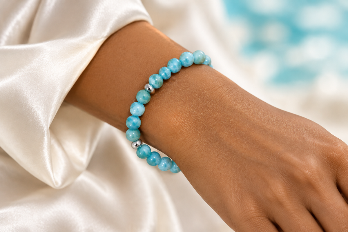 Pulsera de bolas de larimar con detalles de plata puesta en la muñeca de una mujer caribeña