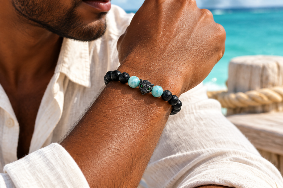 Pulsera de ónix y larimar con jaguar de cristal indossata sul polso di un uomo