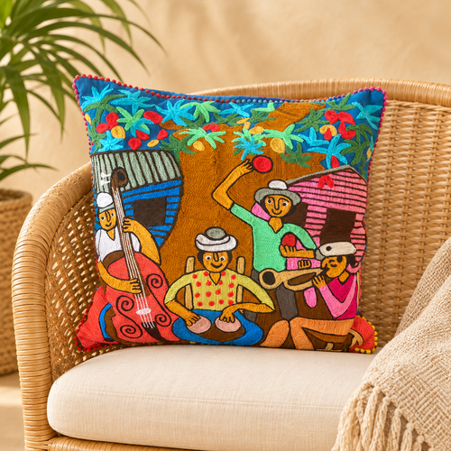 Cojín decorativo bordado con diseño original de José Morillo, sobre una silla de mimbre