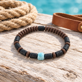 Pulsera de larimar, piedra de lava y caucho sobre madera clara con cuerda y cuero.