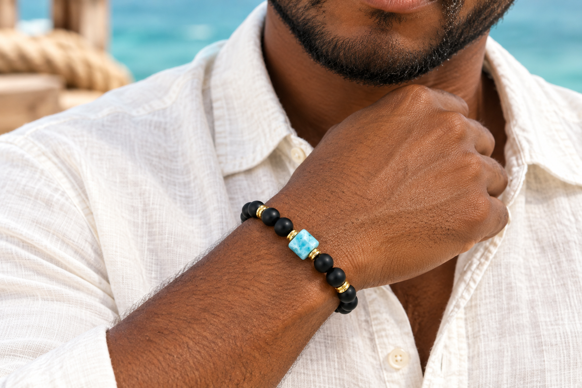 Pulsera de ónix mate y larimar con ambos pares de detalles dorados, puesta por un hombre
