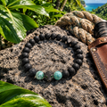 Pulsera de ónix y larimar con jaguar de cristal sobre roca volcánica con hojas de selva tropical, cuerda y cuero