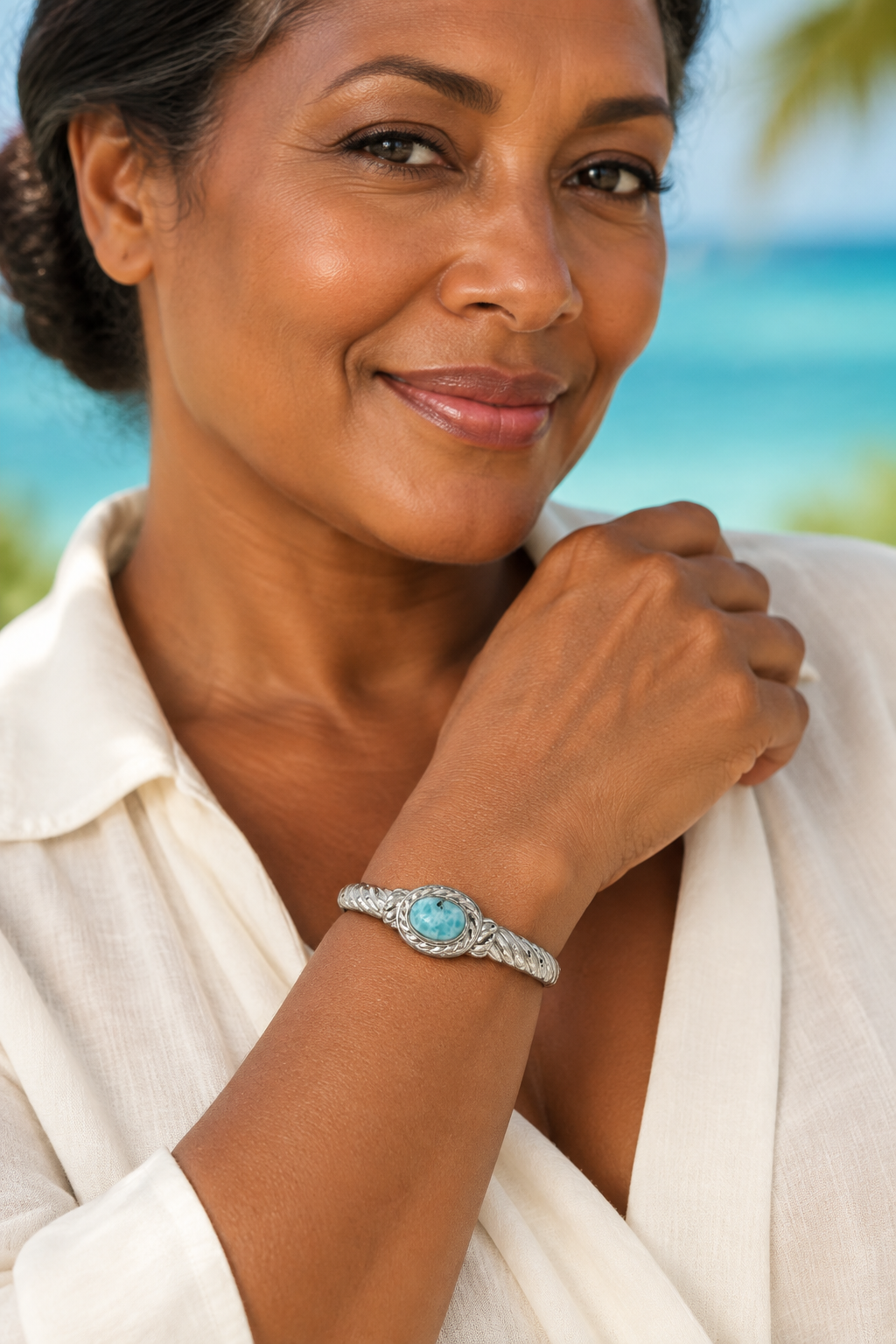 Pulsera de plata y Larimar lucida por Maria, modelo caribeña madura con blusa marfil
